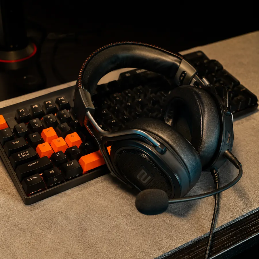 Auriculares gamer con micrófono sobre un teclado mecánico de teclas naranjas