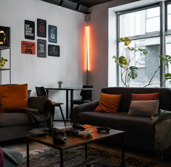 Sala de estar del club con sillones, luz cálida y juegos de mesa